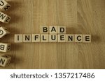 Small photo of Bad influence text from wooden blocks on desk