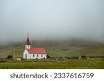 Small photo of In the remote developed village of Vik, Reiniskirkja Church stands amidst the desolate and dazzling landscape of Iceland's South Coast. Surrounded by an amazing environment of rocks, glaciers and volc