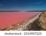 Small photo of Pink Lake in Port Gregory in Western Australia, colored water by bacteria and algae, beautiful contrast between the blue ocean and pink water, clouds on the sky, aerial view.