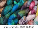 Small photo of Multiple skeins of colourful handdied sock yarn, sock wool, with extreme vibrant colours for knitting socks and other craft projects as a hobby.