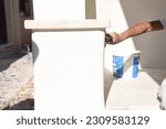 
People painting white plaster in Santorini
