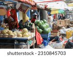 Small photo of Sidoarjo, Indonesia – May, 9 2023 : A child who is fast asleep under the hot sun while accompanying his mother to sell fruit in the market