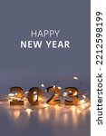 Small photo of Garland. Christmas lights. Christmas, winter, new year concept. Merry Christmas and Happy New Year. Holiday. Happy New Year 2023 poster. Christmas background with big golden numbers 2023.