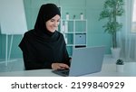 Small photo of Islamic Muslim successful woman in black hijab celebrate victory triumph look at laptop screen shocked close mouth with astonish winning lottery bid at home office got prize feel surprise opportunity