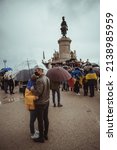 Small photo of Lisbon, Portugal - March 20, 2022: a protest action in support of Ukraine, against Russian invasion and aggressive war: a couple under umbrella staying aloof from the crowd of protesters