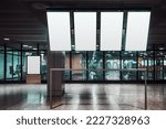 Small photo of Four vertically oriented blank mock-ups of tv screens of a departure and arrivial board, and a template of an indoor ad billboard aloof near a glass wall of an airport or a train station waiting hall