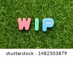 Toy foam letter in word WIP (Abbreviation of work in progress)  on green grass background