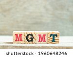 Small photo of Alphabet letter block in word MGMT (abbreviation of Management)on wood background