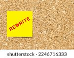 Small photo of Yellow note paper with word rewrite on cork board background with copy space