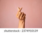 Finger heart. man hand with french manicure gesturing isolated on pink background