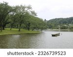 Small photo of yokohama japan -06252023 : small lake pond in Yokohama Sankeien Garden in japanese design. Yokohama Sankeien Garden is one of the famous japanese garden in japan. with a small boat in the middle