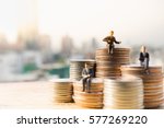 Miniature people: Small businessmen sitting on stack of coins, Money, Financial, Business Growth concept.