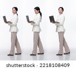 Small photo of Full length 20s Asian Woman wear formal business blazer suit dress pant shoes. Black long straight hair female hold laptop work confident, walk forward turn left right, white background isolated
