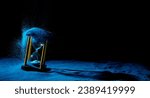 Small photo of Hourglass is sand of time age, Life pour blue sand into hourglass to add more limited time. Deadline extended time management hope concept hour glass. Black background shadow life clock passing by