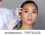 Small photo of Asian Doctor Nurse check face cheek bone structure before plastic surgery and inject beauty chemical syringe to patient with acne, wart, Studio lighting grey background