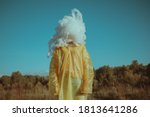 woman in a yellow cloak with a cloud instead of a head
