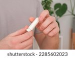 Small photo of Adult man uses nasal stick inhaler to smell for relieve dizzy and faint symptoms.