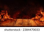 Small photo of wooden table with Fire burning at the edge of the table, fire particles, sparks, and smoke in the air, with fire flames on a dark background to display products