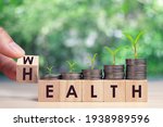 Hand flip wooden cube with word wealth to health with coins stack step up growing growth value. Investment in life insurance and healthcare concept