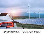 EV Car or electric power car and solar cells for electricity generation,plug of power cable electric supply during charging at ev car.