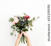 Small photo of Girl's hands holding beautiful flowers bouquet: bombastic roses, blue eringium, eucalyptus, isolated on white background. Flat lay, top view. Floral composition