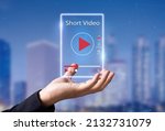 Short Video marketing concept.Man hands holding virtual short video player with blurred city as background