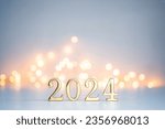 Golden digits in 2024 number with bokeh lights in the background. 2024 new year backdrop. Light and soft
