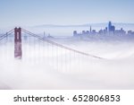 Golden Gate and the San Francisco bay covered by fog, the financial district skyline in the background, the Salesforce tower almost finished, as seen from the Marin Headlands State Park, California