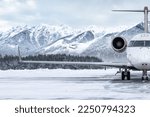 Small photo of Front view of the luxury private jet on the winter airport apron on the background of high picturesque mountains