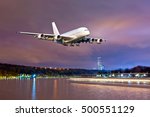White passenger airplane in the colorful night sky. Aircraft flies over the river.