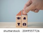 The investor's hand placed a wooden cube with word Work on wooden table. concept work from home, Planning to buy property concept ,food Clothing, housing, medicine, four basic human needs concept.