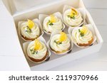 Cupcakes  decorated with dried lemon and thyme  in delivery paper box. Sweet food delivery. Fruits cup cakes, menu design or recipe background
