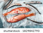 Small photo of Fresh trill fish (triglia) or red mullet and sardines on paper background