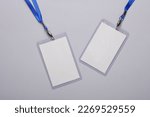 Empty white ID card badges mockup with blue belts on gray background. Staff identity name tags. Space for text and design. Top view. Flat lay