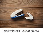 Small photo of Anti-stapler with stapler on wooden table
