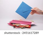 Hand holding a blue envelope...
