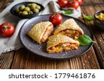 Delicious puff pastry pizza triangle rolls stuffed with tomato sauce, ham, cheese, corn, olives and sprinkled with sesame seeds