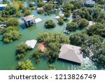 Small photo of Aerial drone view above a natural disaster. Flooded homes with water up to the roof tops massive flooding all along the Colorado River with search and rescue out looking for survivors