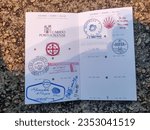 Small photo of Santiago de Compostela - August 12, 2023: Credential of St. James Pathway (Camino de Santiago) to Santiago de Compostela, stamped by stores, churches, and waypoints along the way.