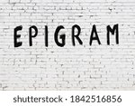 Small photo of White brick wall with inscription epigram handwritten with black paint