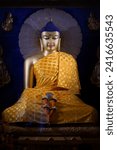 Small photo of Bodhgaya, India - Nov 20 2023: View of gilded Buddha image in the sanctum of the Mahabodhi Temple, in earth-touching or Bhumisparsha mudra, clothed in yellow robe