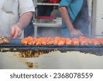 Street food of Asia: barbecue chicken tikka on the local food street of Burns Road. Grilled chicken Chargha chicken on skewers