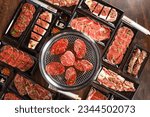 Small photo of Raw beef slice for barbecue japanese style, yakiniku. Meats are being cooked on the stove in a japanese restaurant.