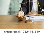 The lawyer puts a second hand on the scales of justice on his desk, stating that the matter must be justified and not contrary to law and humanity. The concept of legal jurisprudence.