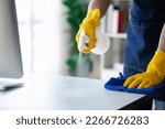 Small photo of Person cleaning the room, cleaning staff is using cloth and spraying disinfectant to wipe the glass in the company office room. Cleaning staff. Maintaining cleanliness in the organization.
