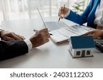 Small photo of House insurance paperwork, A realtor is explaining home insurance documents to a buyer in his office at the company, Sign home insurance documents, make an agreement together.