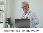 Small photo of A dignified middle-aged male doctor was sitting in his private office at the hospital, Doctors are sitting and working in various poses. at the hospital happily and happily at work