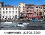 Small photo of Venice, Italy - February 12, 2022: Small boats whiz by in the Grand Canal, people are present.