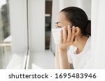 Tired doctor in medical mask looking through window. Important job and self isolation during coronavirus pandemic. Hope for medicine.