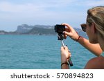 European girl tourists enjoy the GoPro camera and view of the island and the sea on the boat.
